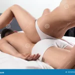 Couple Doing Erotic Massage in Bedroom. Stock Photo