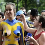 NUDE crowds parade through New York in raunchy body paint party